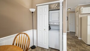 Une buanderie équipée d’un lave-linge et d’un sèche-linge, d’une chaise et d’un lampadaire.