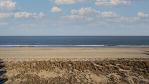 A beach with a sandy shore and dunes in the foreground. - Summer Beach 501 by Seaside Vacations & Sales (Ocean City)