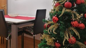 A dining area with a Christmas tree, a framed picture on the wall, and an air conditioning unit. - Centralissimo e luminosissimo appartamento intero con Open Space. (Taranto)