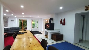 Una sala moderna con una mesa de comedor de madera, un sofá de cuero negro y una chimenea.