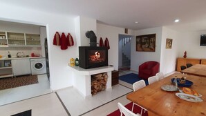 Una sala de estar moderna con chimenea, comedor y cocina.