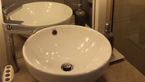 Zwei weiße Keramikwaschbecken mit Chromarmaturen in einem modernen Badezimmer.