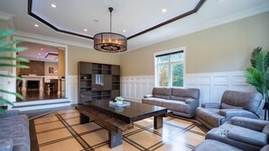 Ein geräumiges Wohnzimmer mit einem großen Couchtisch, Ledersofas und einer integrierten Unterhaltungseinrichtung.