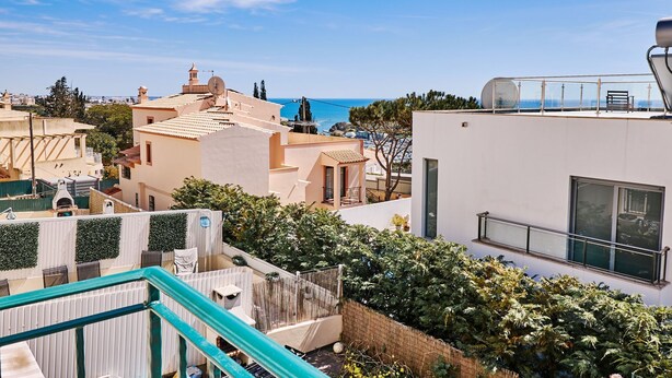 A residential area with a view of the sea, featuring modern buildings with balconies and a rooftop terrace. - Casa Felix with pool (Albufeira)