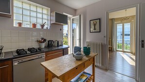 Eine moderne Küche mit einem Holztisch, einem eingebauten Ofen und einem Fenster mit Blick ins Freie.