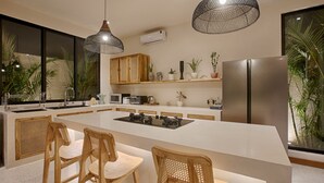 A modern kitchen with a large island, wooden chairs, pendant lights, and a refrigerator. - Villa Nueva Expectacular. Vive Bingin Beach!! Trona, Cuna, Bañera Gratis (Bali)