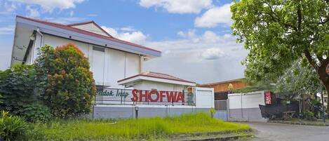 Un bâtiment sur lequel on peut lire l’inscription « SHOPWA 2 » et qui est surmonté d’une antenne parabolique.