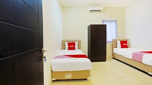 Ein Hotelzimmer mit zwei Betten, einem Kleiderschrank und einer Klimaanlage.