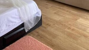 Una habitación con cama, sofá, techo de madera, unidad de aire acondicionado y puerta con ventana.