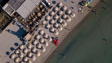 In Strandnähe, weißer Sandstrand, Liegestühle, Sonnenschirme