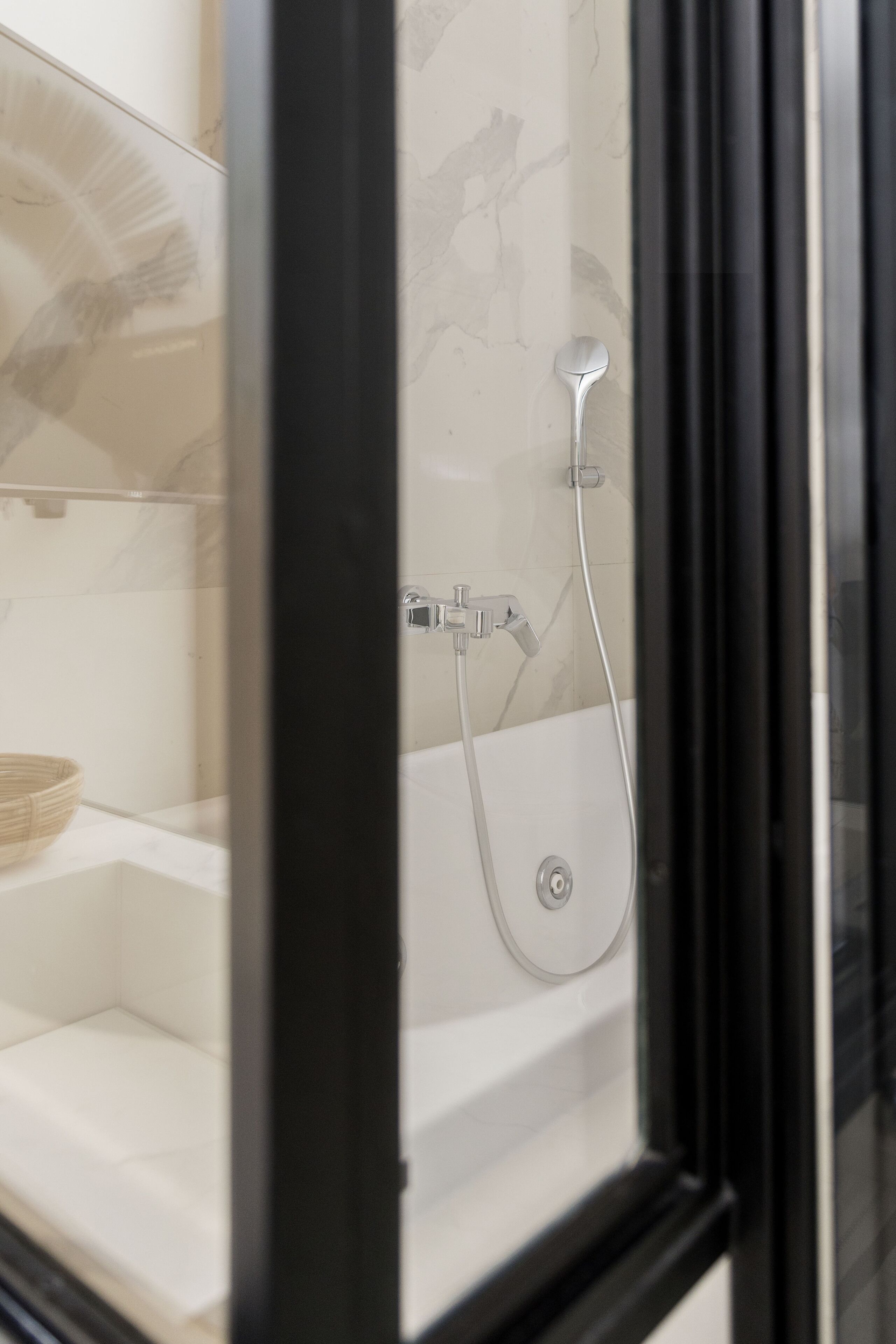 Un bagno con doccia, lavandino e specchio.