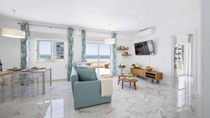Ein modernes Wohnzimmer mit einer Couch, einem Esstisch und einem Fernseher.