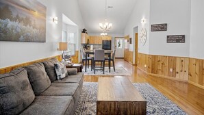 A modern living room with a sofa, coffee table, and artwork on the wall. - River Bear-Riverfront in Pigeon Forge (Pigeon Forge)