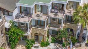A multi-story hotel with balconies, outdoor seating, and lush greenery. - Asterina Hotel (Bodrum)