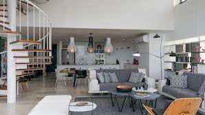 A modern living space with a staircase, dining area, kitchen, and a bookshelf. - Siaan Betine 4br Deluxe PDC  (Playa del Carmen)