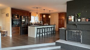 Una cocina moderna con una isla central, armarios de madera y estufa integrada.
