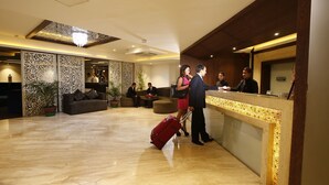 A hotel lobby with a reception desk, seating area, and decorative panels. - Platinum Hotel and Spa (Kathmandu)