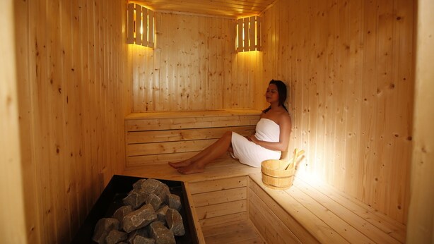 A wooden sauna with benches and a stone basin. - Platinum Hotel and Spa (Kathmandu)