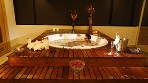 A spa setting with a hot tub, candles, and a bouquet of flowers. - Platinum Hotel and Spa (Kathmandu)