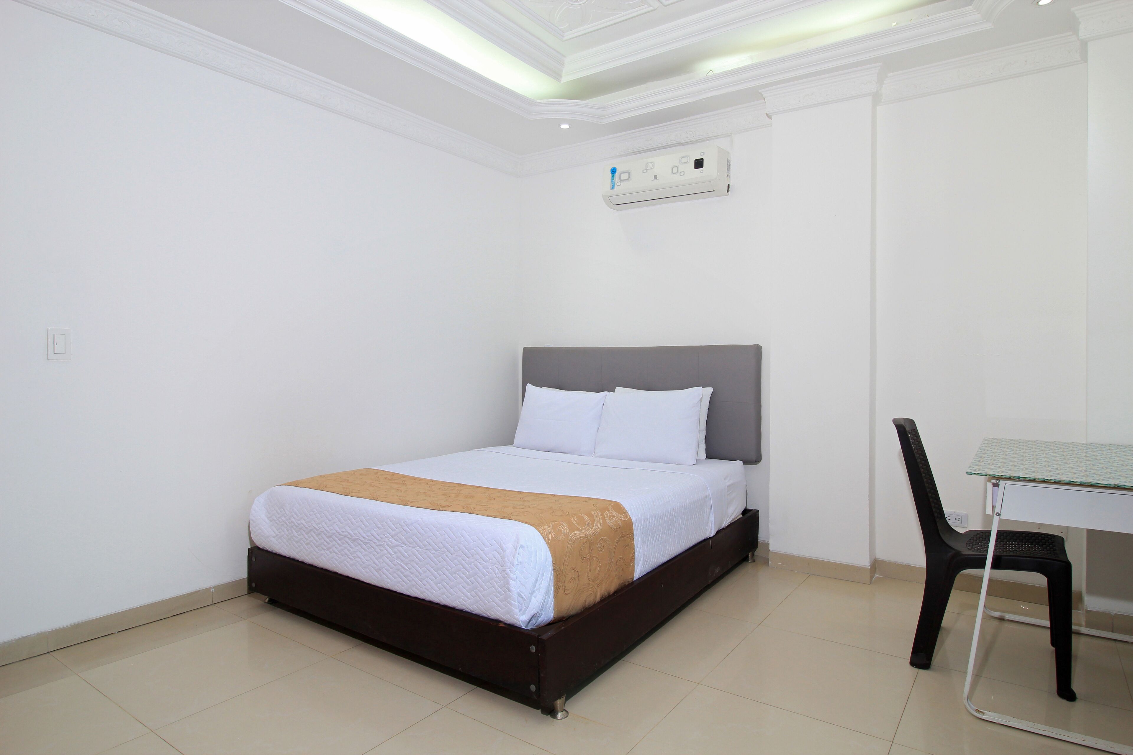 Un dormitorio con una cama, una mesa y una silla.