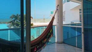 Eine Hängematte auf einem Balkon mit Blick auf einen Strand.