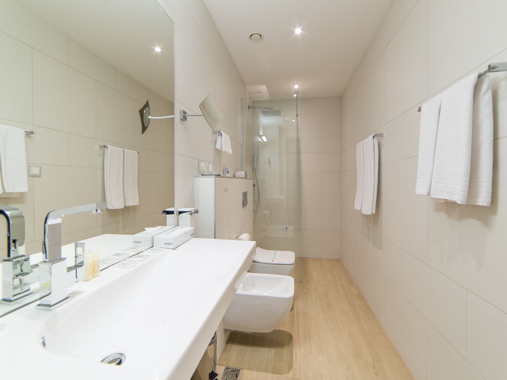 Ein modernes Badezimmer mit großem Waschbecken, Toilette und Duschbereich.