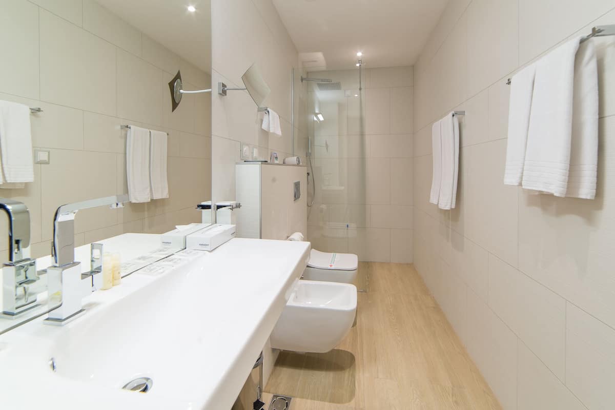 Une salle de bain moderne dotée d’un grand lavabo, de toilettes et d’un espace douche.