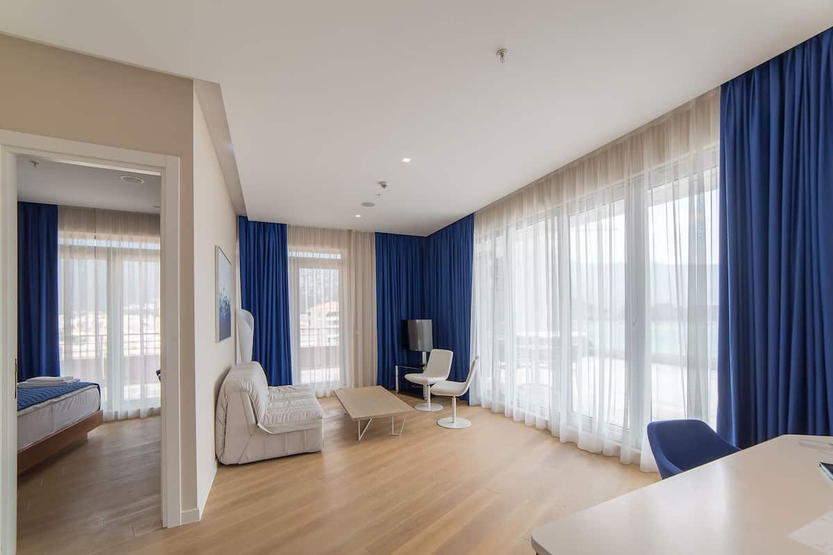 Une chambre d’hôtel moderne équipée d’un lit, d’un canapé, d’une table à manger et d’un téléviseur.