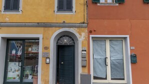 Un edificio amarillo con puerta negra y una tienda en la planta baja.