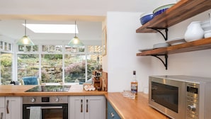 A modern kitchen with a built-in oven, microwave, and wooden countertop. - Riseholme (Scarborough)