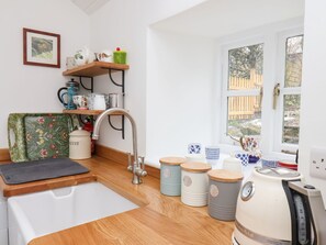A compact kitchen with a sink, wooden countertops, a kettle, and storage containers. - Riseholme (Scarborough)