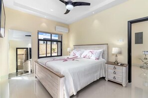 Un dormitorio con cama, mesita de noche y ventilador de techo.