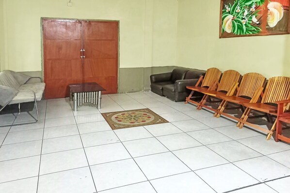 Un área de espera con un sofá, sillas, una mesa de centro y una puerta.