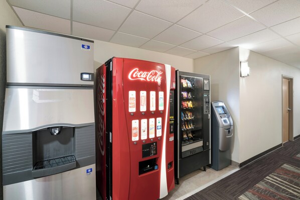 A hotel lobby with a Coca-Cola vending machine, a refrigerator, and a self-service snack machine. - Red Roof Inn & Suites Carrollton, Ga-west Georgia (Carrollton)