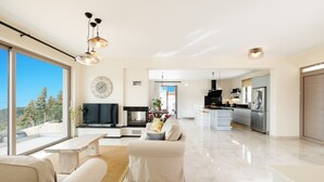 Un salon moderne avec un canapé, une table basse et un téléviseur. Il y a également un coin cuisine équipé d’un réfrigérateur et d’une table à manger.