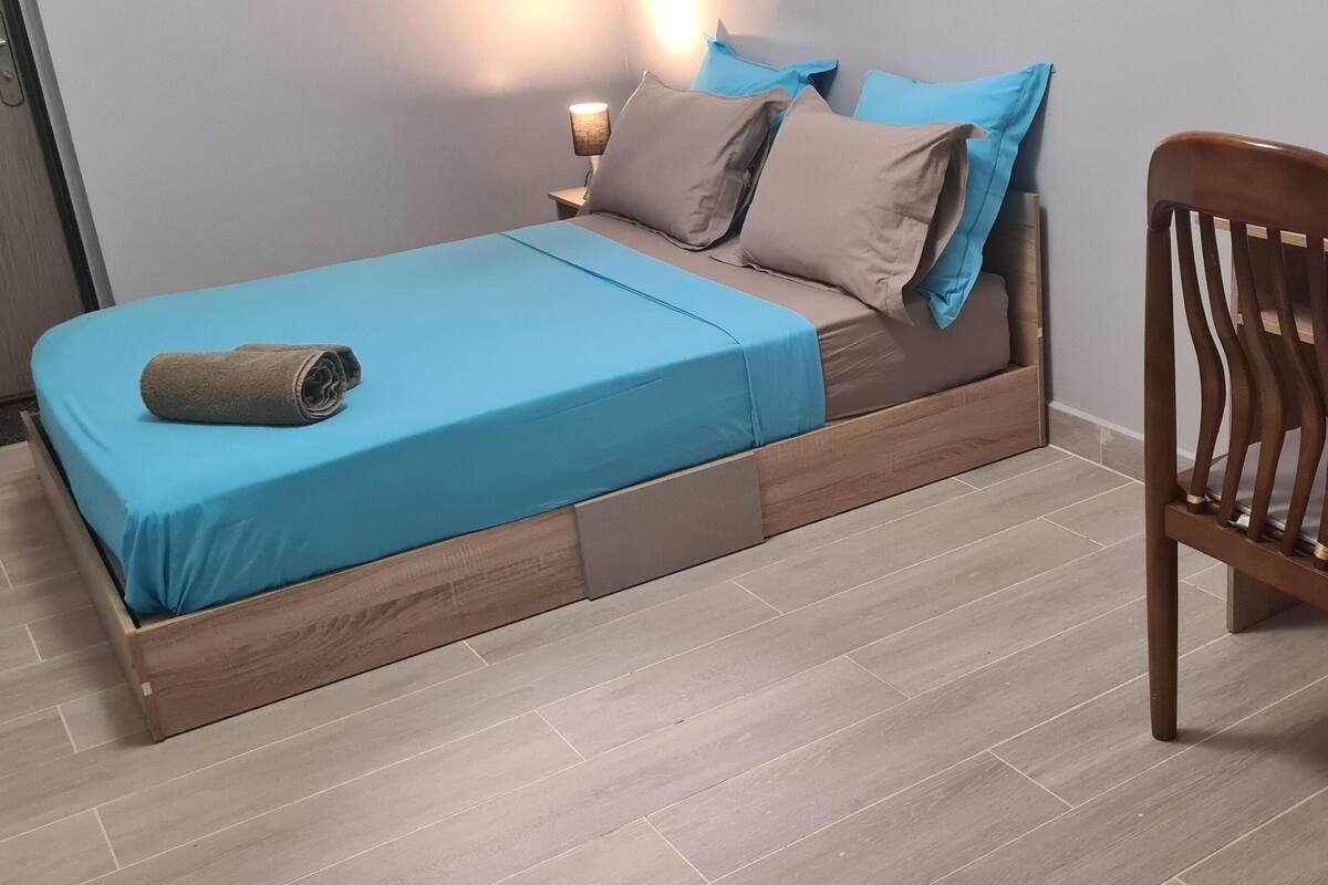 A room with a bed, a desk, and a chair.