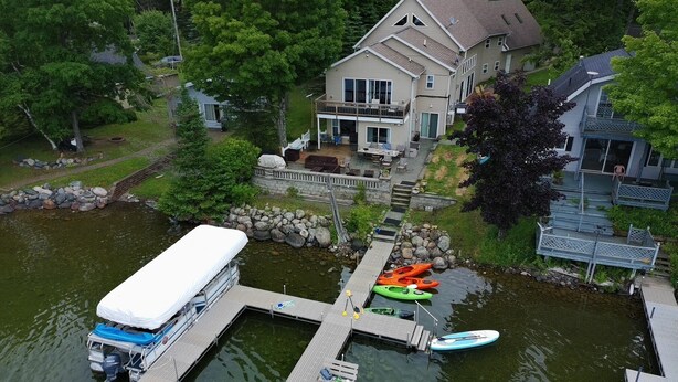 A house with a dock, kayaks, and a paddleboard. - Deepwater Lodge Chicagon Lake- Sleeps 24-Pontoon included-DM for June specials! (Crystal Falls)