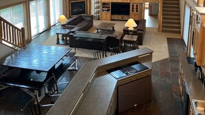 A spacious living area with a high ceiling, wooden beams, and large windows. - Deepwater Lodge Chicagon Lake- Sleeps 24-Pontoon included-DM for June specials! (Crystal Falls)
