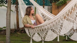 Un'amaca in un giardino rigoglioso, con una persona che si rilassa.