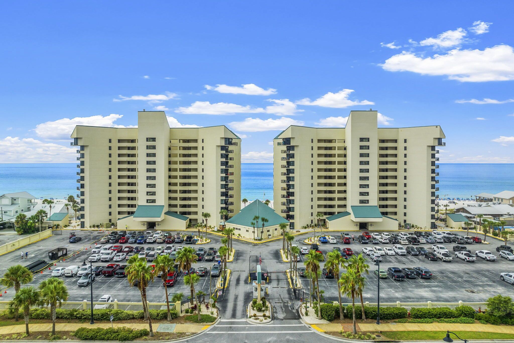 A hotel with a parking lot and a view of the ocean.