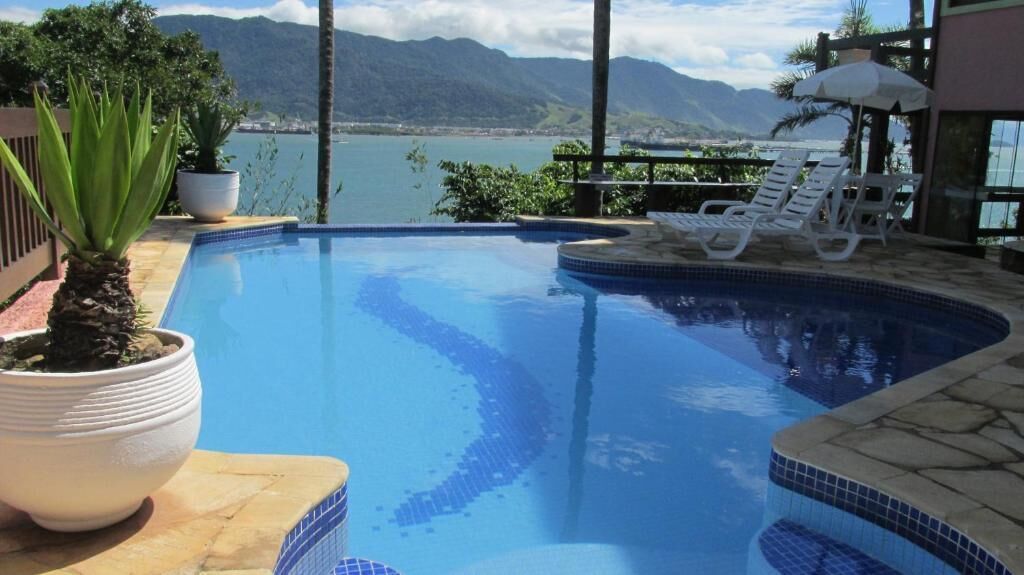 Une piscine avec vue sur les montagnes et un plan d’eau.