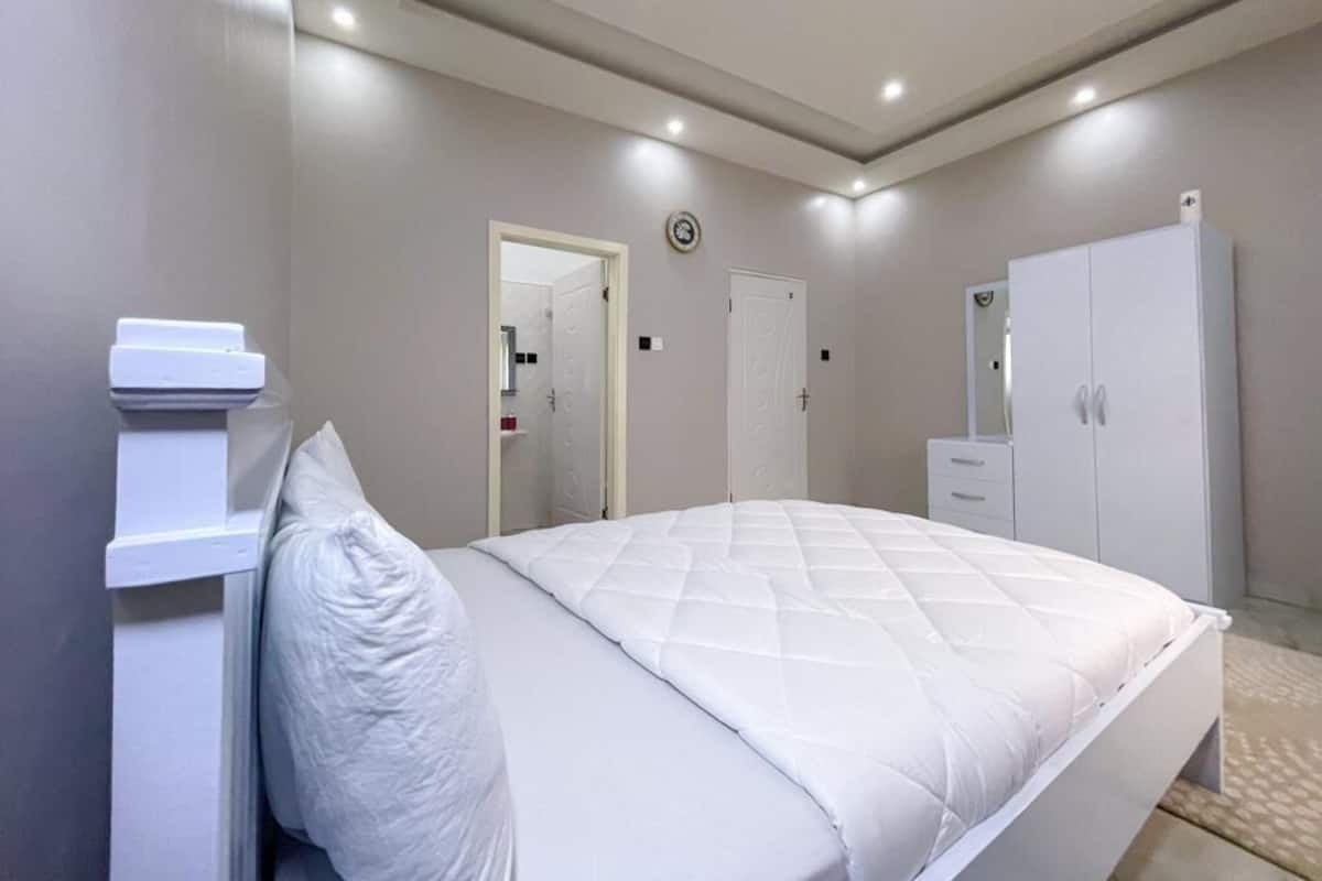 Une chambre à coucher avec un lit, une armoire et un miroir.