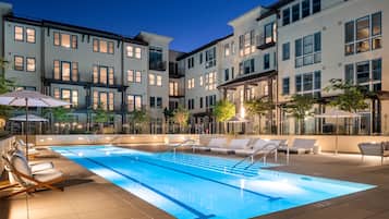 Una piscina al aire libre, sillones reclinables de piscina