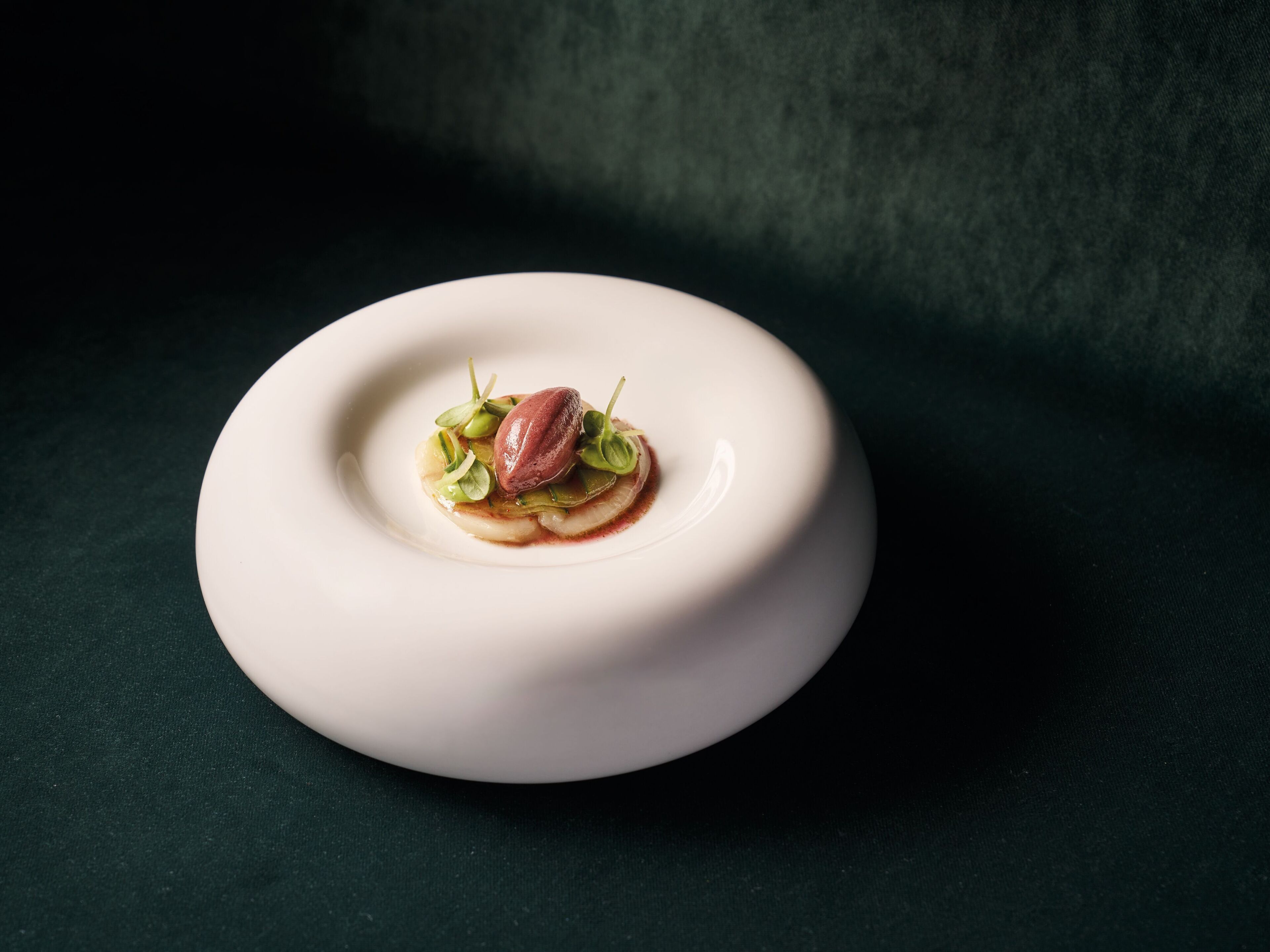 A white plate with a dessert on a dark surface.