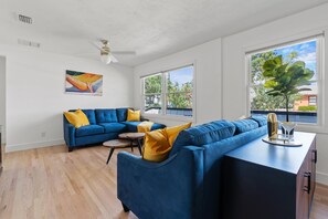 Relax in this inviting living room with a sofa, ceiling fan, and a view of the outdoors.