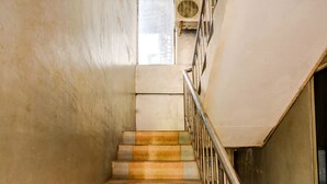 A staircase with a metal handrail and a view of the outside through a window. - Hotel O Hasan House SyariahNearPelabuhan Feri Harbor Bay (Batam)
