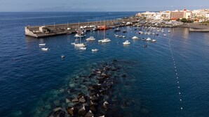 A marina with boats docked, a pier, and buildings in the background. - Beautiful duplex seafront in Playa San Juan with awesome views !!! (Guía de Isora)