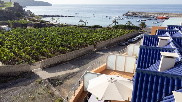 A terrace with a table and chairs, overlooking a vineyard and a coastal view with boats. - Beautiful duplex seafront in Playa San Juan with awesome views !!! (Guía de Isora)