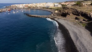 A coastal town with a marina, rocky shoreline, and buildings along the beach. - Beautiful duplex seafront in Playa San Juan with awesome views !!! (Guía de Isora)