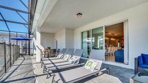 A sunlit outdoor lounge area with reclining chairs and a covered seating area. - Spacious 10Bed Pool Home with Game Room-4265LA (Davenport)